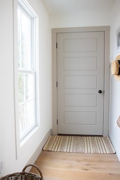 a white door with a basket on the floor next to it