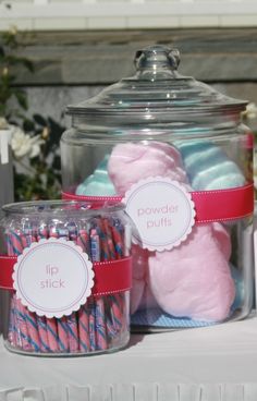 a jar filled with lots of pink and blue candies on top of a table