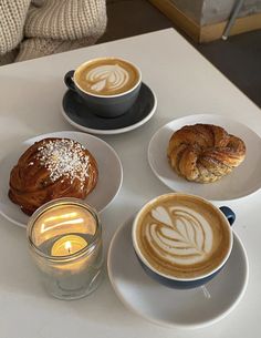 there are four different types of coffees on the table and one has a croissant