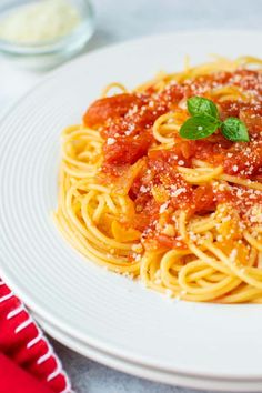 a white plate topped with spaghetti and sauce