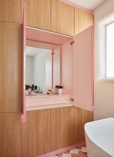 a bathroom with pink and white decor on the walls, sink and bathtub in it