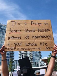 a person holding up a sign that says it's a prilvege to learn about racism instead of experiencing 4 your whole life