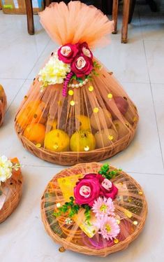 three baskets with flowers and fruit in them