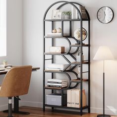 a room with a desk, chair and clock on the wall next to bookshelf