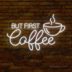 a neon sign that reads but first coffee on a brick wall with a cup of coffee