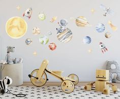 a child's room with space wall decals and wooden toys on the floor