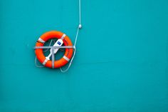 an orange life preserver hanging on the side of a blue wall