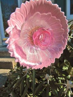 a large pink flower sitting on top of a green plant