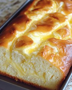 a loaf of bread sitting on top of a pan covered in melted cheese and butter