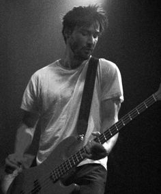 black and white photograph of man playing bass guitar