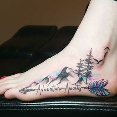 a person with a tattoo on their foot that says adventure awaits and an arrow