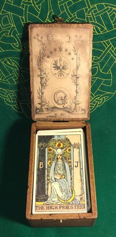 the high price tarot box is open on a green tableclothed surface with an intricate design