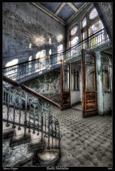 an old building with stairs and windows in the center, surrounded by tiled flooring