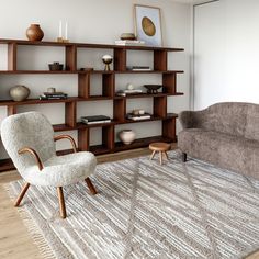 a living room with a couch, chair and bookcases on the wall behind it