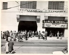 an old black and white photo of people standing in front of a movie theater