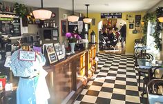 the inside of a restaurant with checkered flooring and black and white tile floors