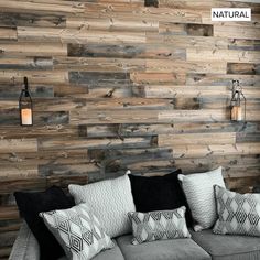 a living room with wood paneling on the wall and pillows on the couches