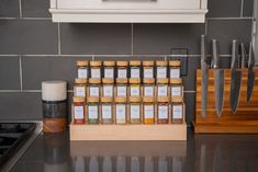 a kitchen counter with spices on it and knives next to the spice rack in front