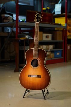 an acoustic guitar sitting on top of a stand