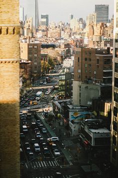 a city street filled with lots of traffic next to tall buildings and skyscrapers in the distance