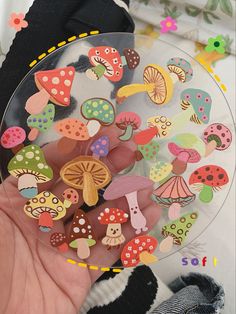 a person holding a glass plate filled with lots of different types of mushrooms on it