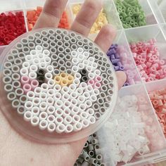 a hand holding a plastic bead kit in it's palm