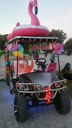 a golf cart decorated with flamingos and lights