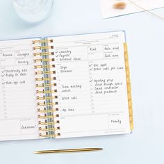 an open planner book sitting on top of a desk next to a cup of coffee