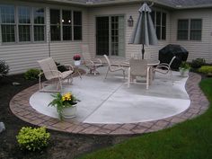 a patio with chairs and an umbrella on it