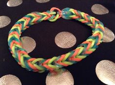 a multicolored bracelet sitting on top of a polka dot covered table with silver circles