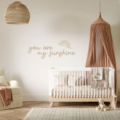 a baby's room with a crib, rocking chair and wall decal that says you are my sunshine