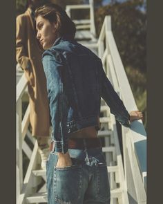 a woman standing next to a man on top of a white stair case in front of stairs