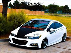 a white car with black stripes parked on the street