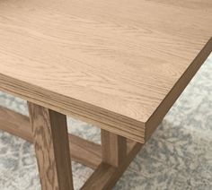 a close up of a wooden table on a carpeted floor with blue and white designs