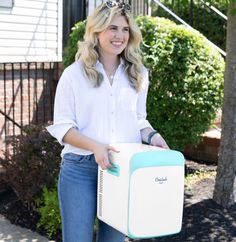 a woman is holding a cooler in her hands