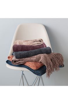 several folded towels sitting on top of a white chair