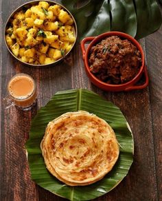 some food is on a wooden table and there are plates with different types of food