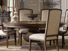 a dining room table and chairs with chandelier in the background on carpeted floor