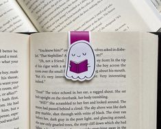 a bookmark with a ghost reading a book on top of an open book,