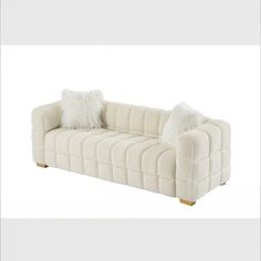 a white couch with two pillows on it's back and one pillow in the middle