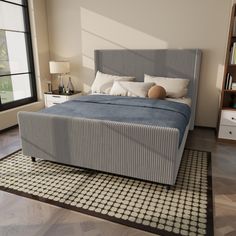 a bed sitting on top of a wooden floor next to a window