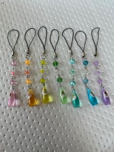 six different colored glass bottles are on a white surface with a black cord in front of them