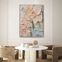 a painting hanging on the wall above a white table in a room with beige chairs