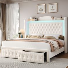 a white bed with an illuminated headboard and foot board on top of it in a bedroom