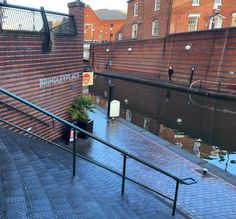 the stairs lead up to an area with water and brick walls