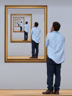 a man standing in front of a mirror looking at himself in the same way as he looks at his reflection