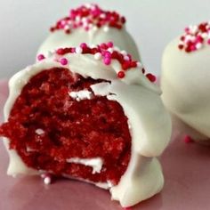 red velvet cake balls with white frosting and sprinkles on a pink plate