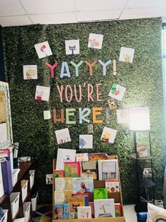 there are many books on display in the room with green walls and letters written on it