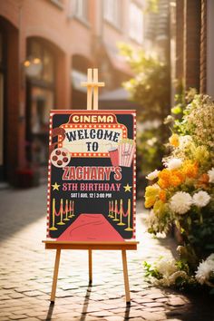 a sign for a birthday party with flowers in the background