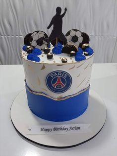 a birthday cake with soccer balls and a man on top is decorated in blue and white